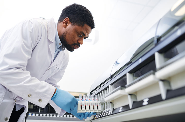 black-doctor-working-with-pharmaceutical-machine-2021-09-24-03-59-22-utc.jpg A man works with pharmaecuticals in a lab