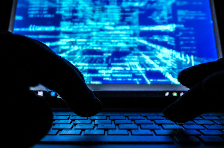 cybercrime-cyber-security-2021-09-02-07-43-20-utc.jpg Digital image of hands on a laptop showing lots of code