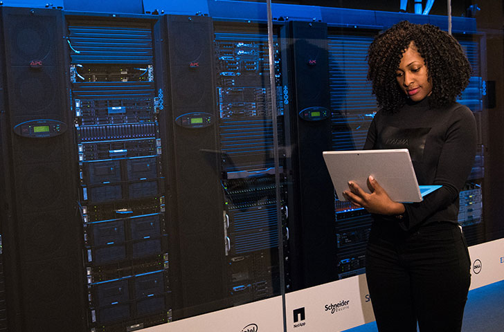 pexels-christina-morillo-1181354.jpg Black woman viewing a laptop in front of a data center