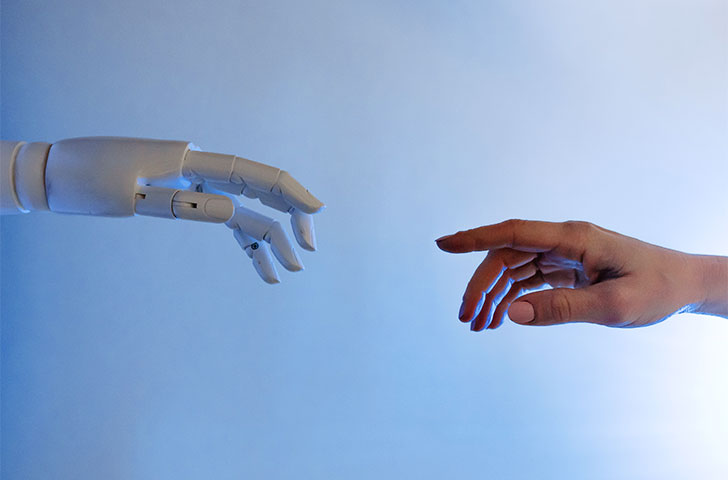 pexels-tara-winstead-8386434.jpg A robot hand and human hand almost touching