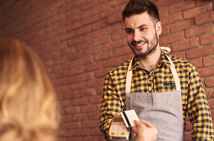 waiter-with-credit-card-reader-waiting-for-payment-2021-08-27-09-43-53-utc.jpg Waiter holds out a wireless credit card reader to a guest waiting to pay