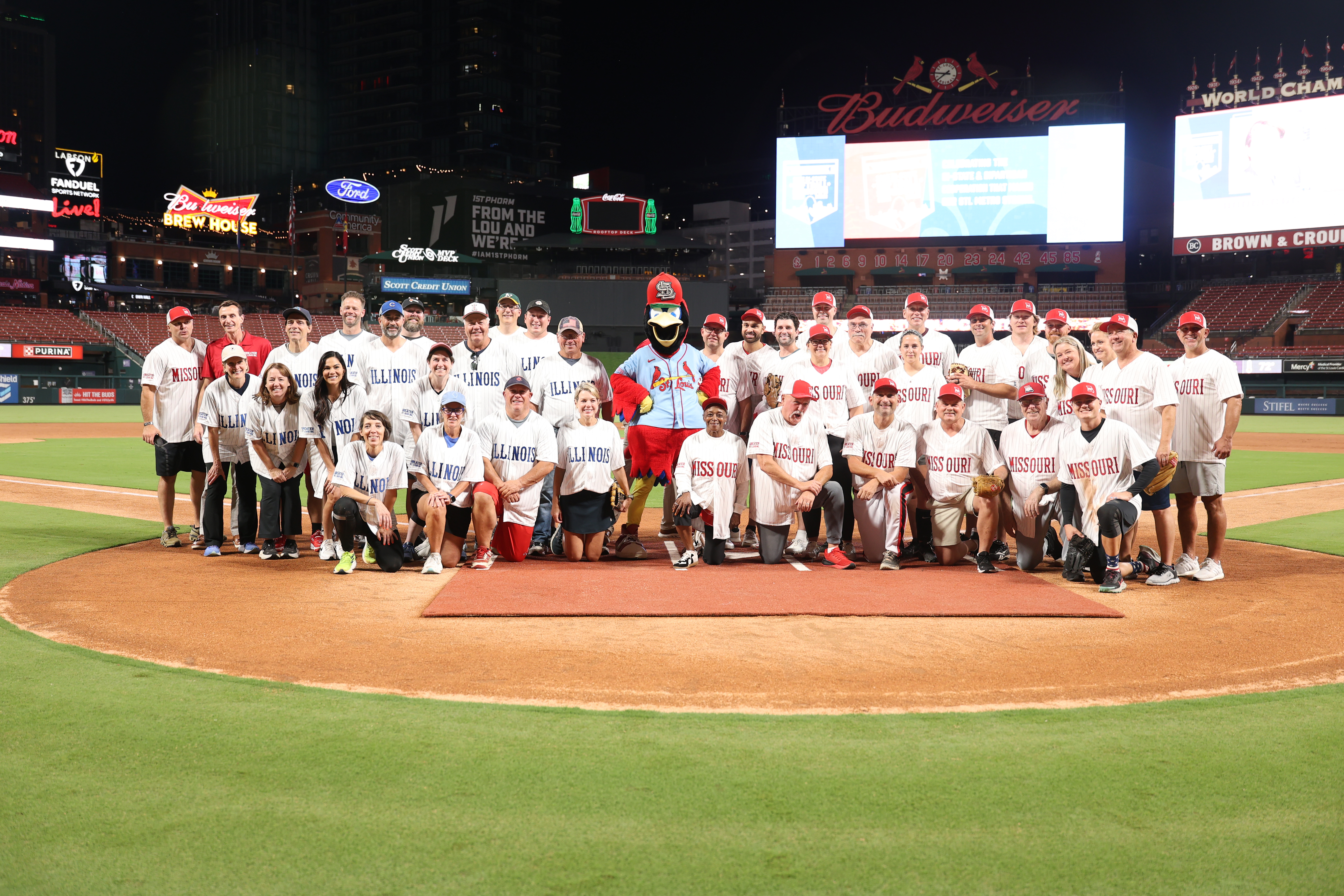 2025 Bi-State Softball Showdown - Group Photo At the Greater St. Louis, Inc. 2025 Bi-State Softball Showdown, MO and IL teams pose together on the field at Busch Stadium.