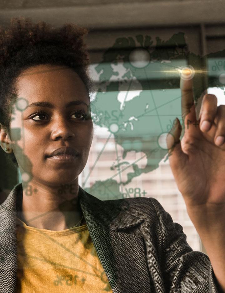 Black woman reviewing geospatial data on a large touchscreen display