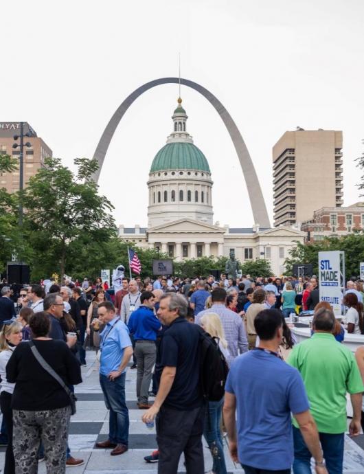 crowd of people congregating in front of the St. Louis Arch