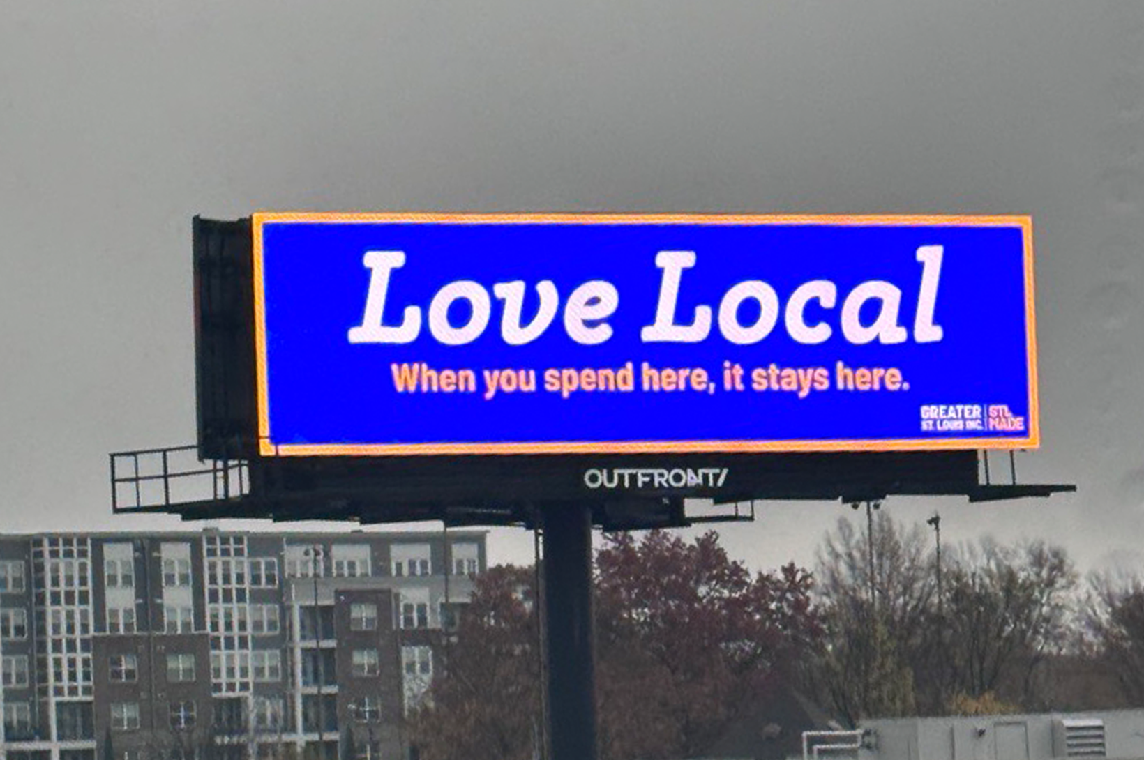 A bright blue Love Local billboard reminds St. Louis shoppers to buy local.