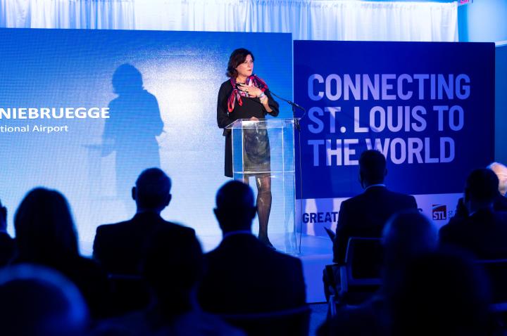 Rhonda Hamm-Niebruegge speaking on stage at the announcement of a new Lufthansa flight to St. Louis.