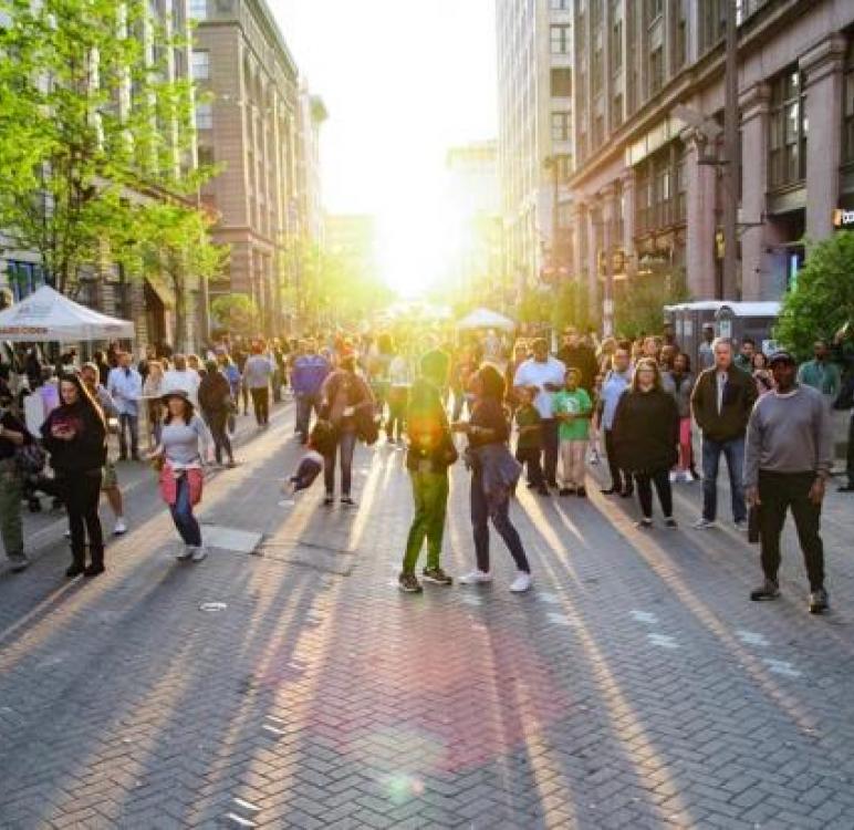 People happily walking on the sunlit street in Downtown St. Louis
